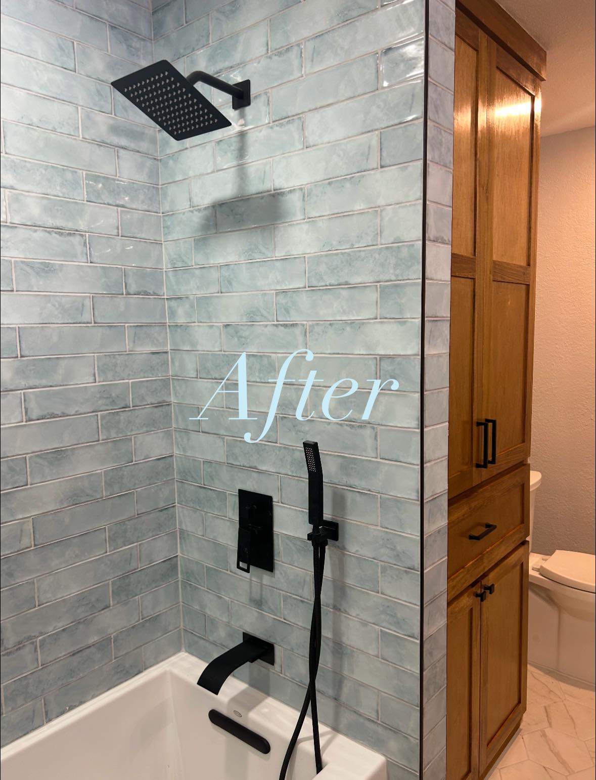 Bathroom shower with aqua zellige-style tile and matte black rain showerhead