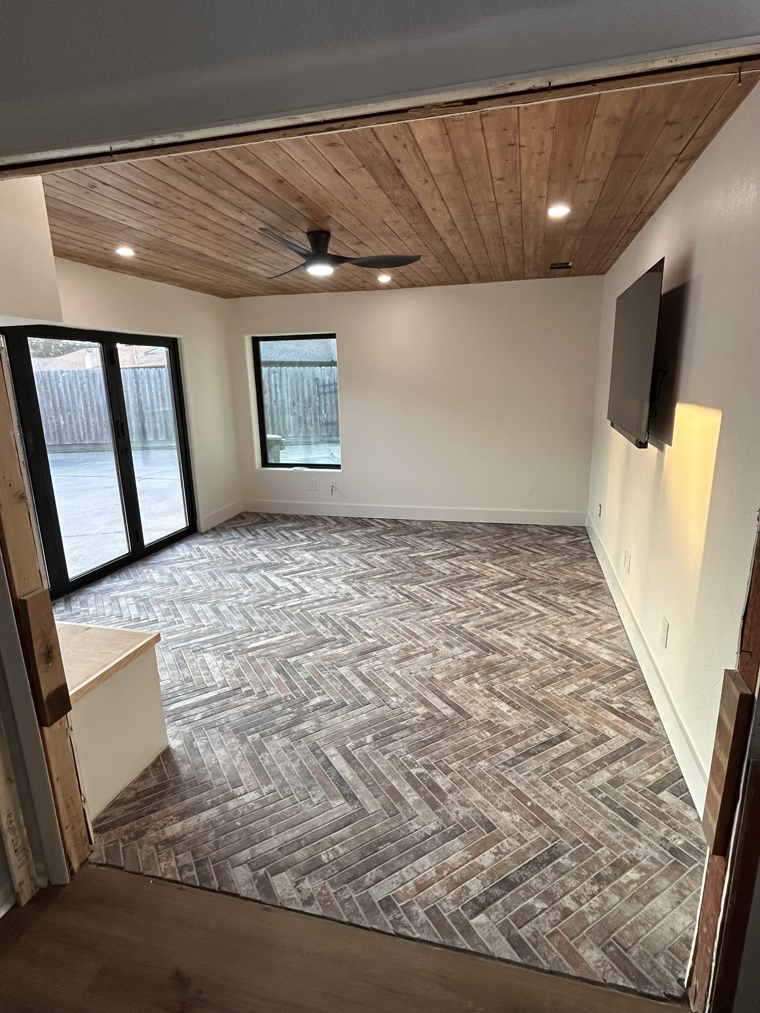 Room addition with herringbone wood-look tile floor and cedar plank ceiling