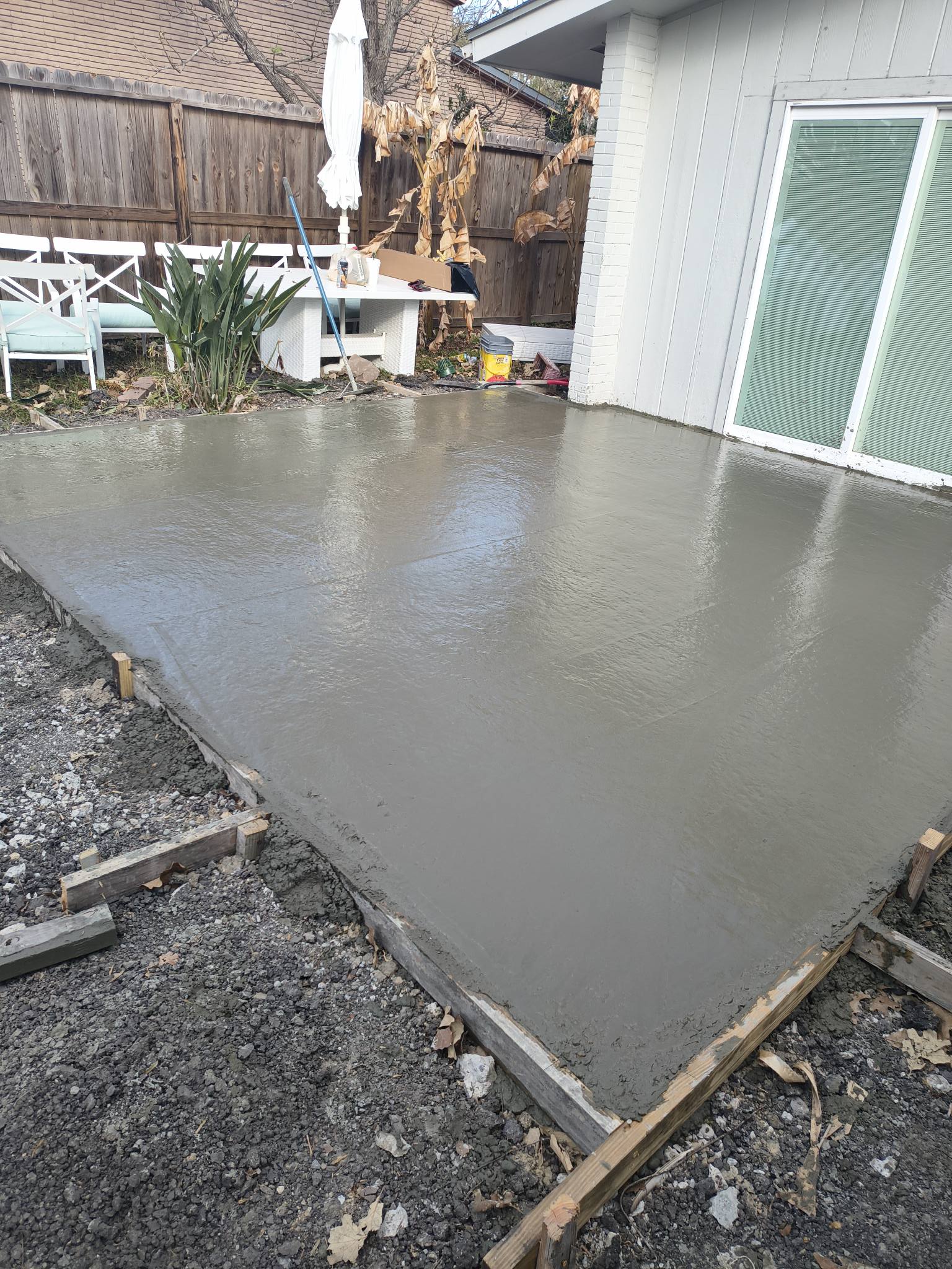 Fresh concrete patio slab pour in residential backyard