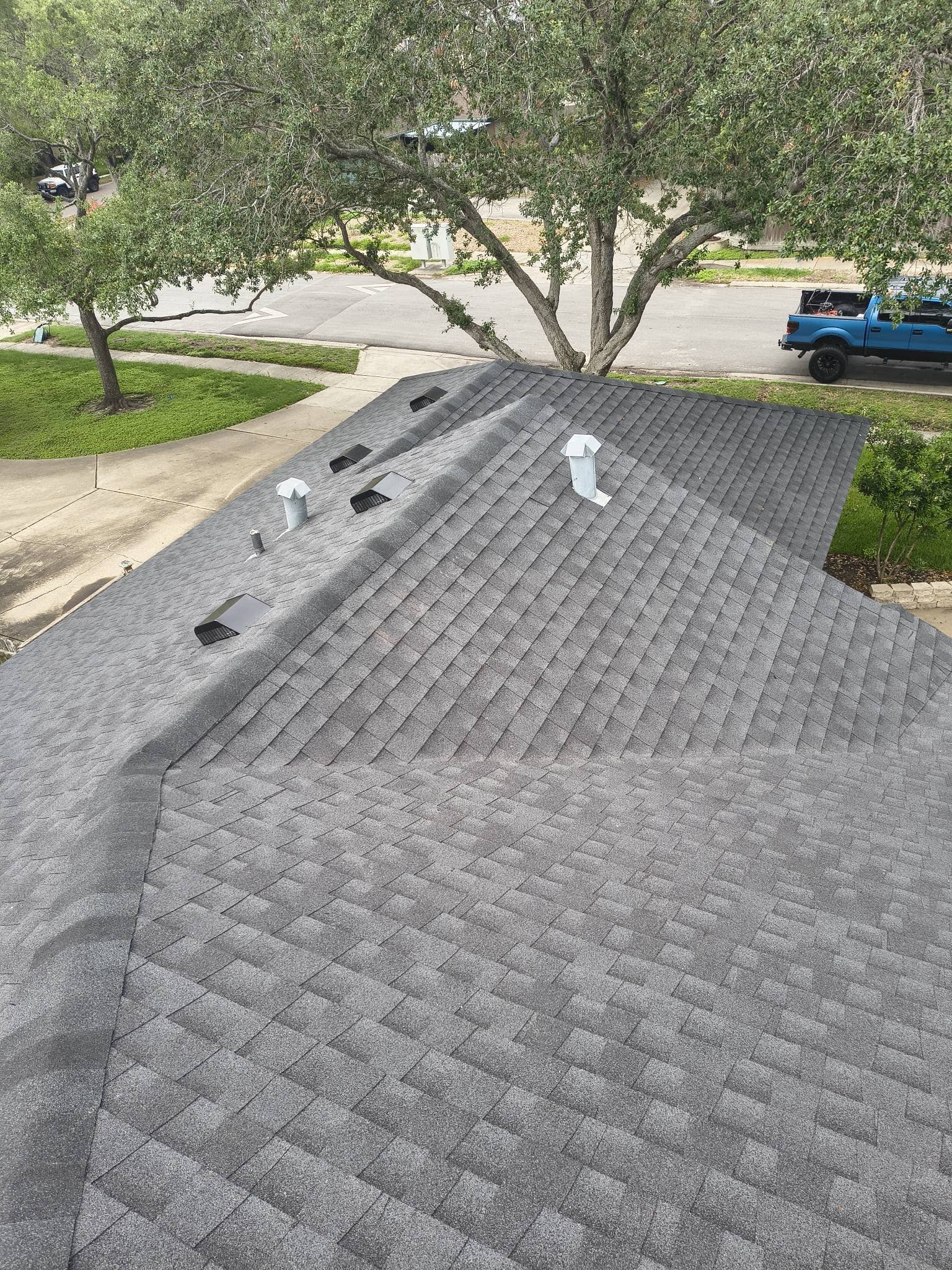 Completed residential roof with gray architectural shingles