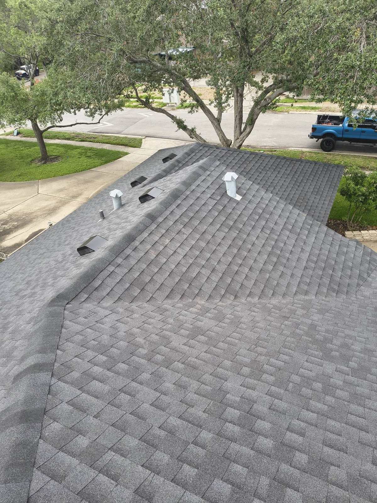Aerial view of a completed residential roof with gray architectural shingles