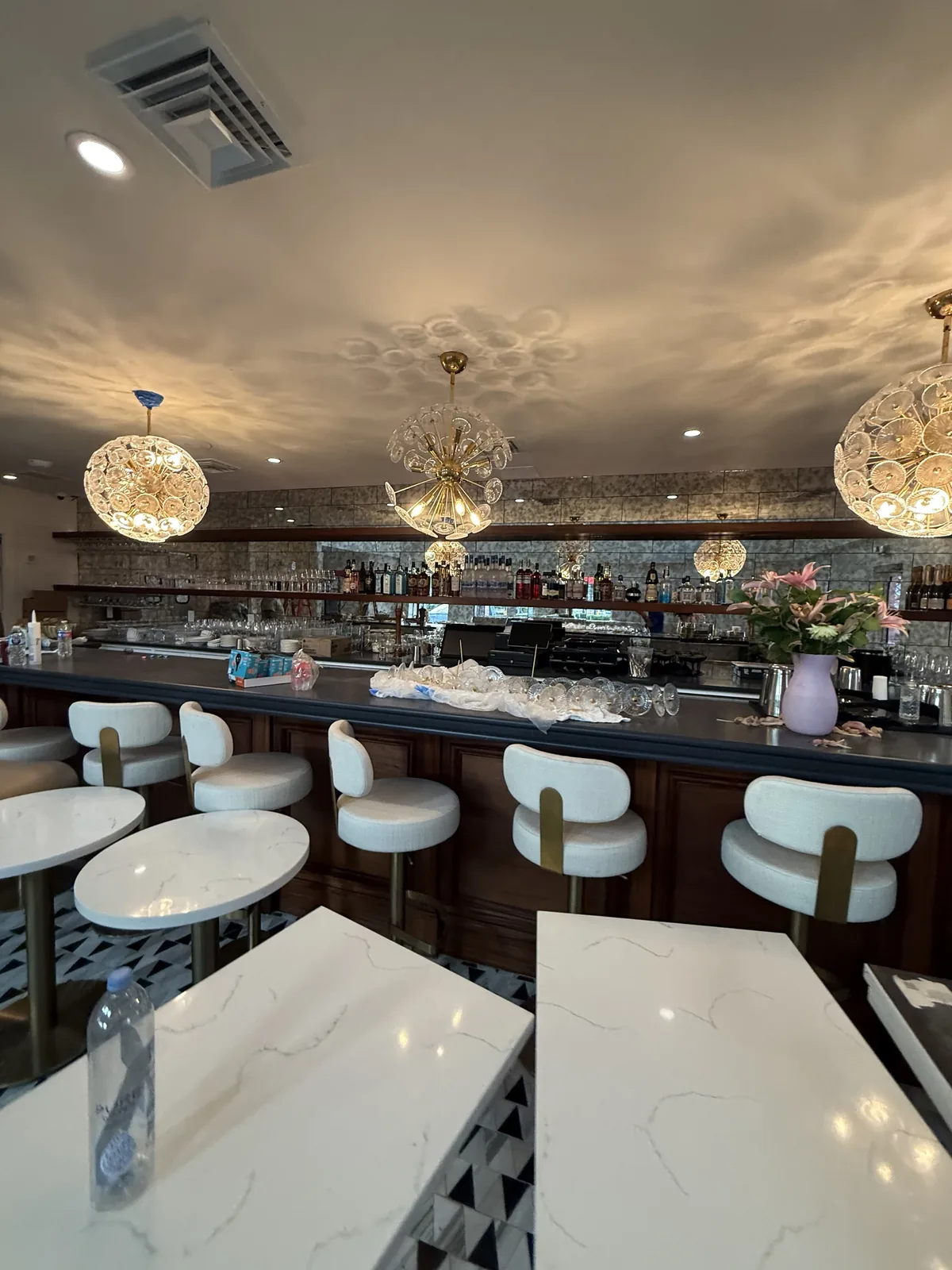 Bar and quartz-top dining tables with custom lighting