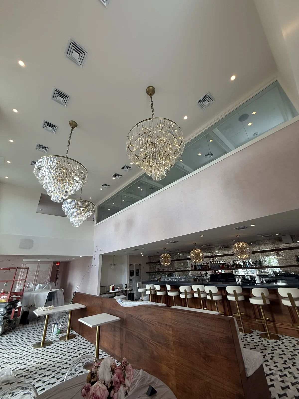 Double-height dining room at Bien Merité with mezzanine and chandeliers