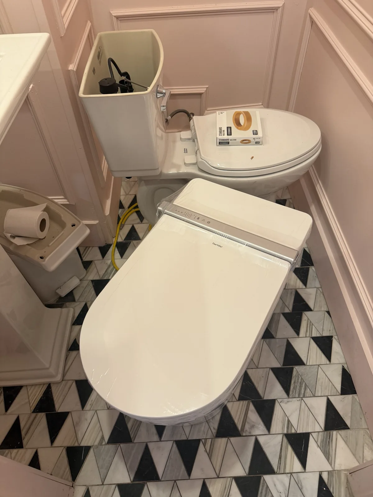 Restroom with custom marble tile floor and paneled millwork